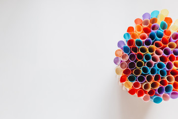 pile of colorful cocktail straws over white background
