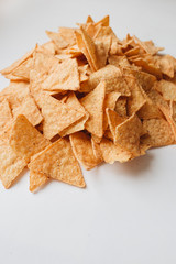 pile of delicious crispy nachos on white background, traditional Mexican cuisine