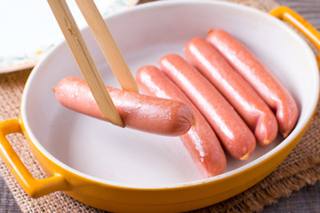 Barbecue sausages in the form for baking on wooden table