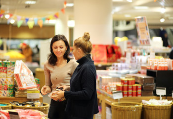Two women choosing a dairy products at supermarket.selective focus.