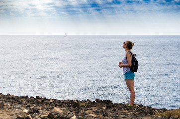 Woman standing by a rocky shore, Tenerife, Spain