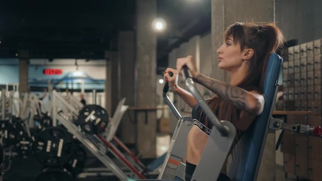 Sport. Beautiful woman in gym doing chest muscles training workout girl brunette athlete hard crossfit
