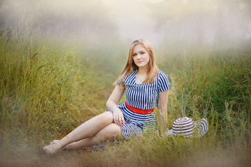 Девушка-подросток сидит на траве летом в парке © jloginova