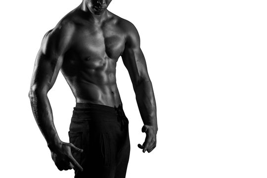 Highly retouched black and white fitness model and bodybuilder, Looking and posing abs and chest. concept of power and strength. Isolated on white background. Copy space.
