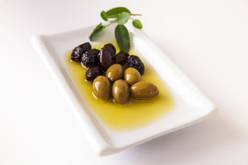 fresh,tasty, dark,green olives served in olive oil on white background