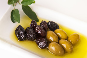 fresh,tasty, dark,green olives served in olive oil on white background