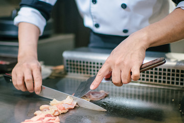 Hand of man take cooking of meat with vegetable grill, Chef cooking wagyu beef in Japanese teppanyaki restaurant