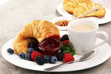 Delicious breakfast with fresh croissants and ripe berries and jam
