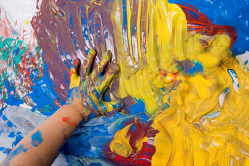 Hand eines Kleinkinds verschmiert Fingerfarbe auf dem Boden - obrazy, fototapety, plakaty