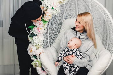 parents with the baby on the swing in the room smile