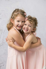 Happy Sisters in Pink Dresses Smiling Girls