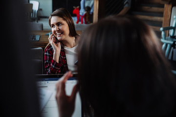 young businesswoman talking on the phone in cafe