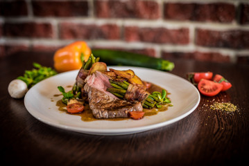 Steak chicken breast olive oil cherry tomatoes pepper and rosemary herbs.