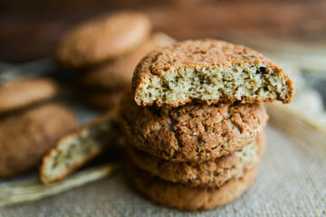 fresh homemade oatmeal cookies on wooden background with spikes of oats