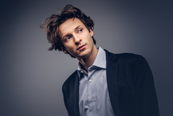 Studio portrait of a stylish sensual male with hairstyle in a casual suit