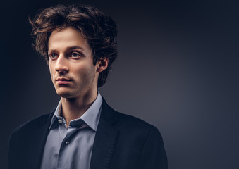 Fototapeta premium Studio portrait of a stylish sensual male with hairstyle in a casual suit