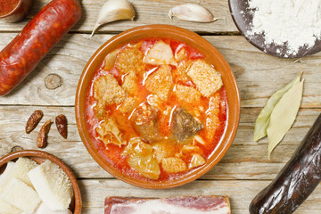 Spanish callos and ingredients on a white blackground