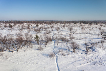 arial shot of snowy landscape with footpath