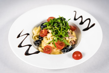 Pasta with vegetables on plate, traditional Italian food, pasta, tomatoes, rucola