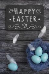 Easter eggs on a dark wooden background and chalk hand-drawn lettering