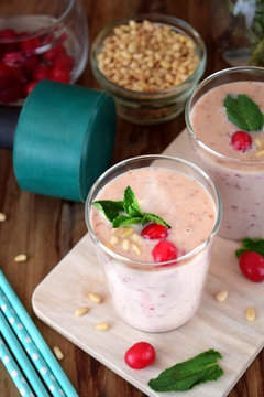 Protein cocktail for healthy nutrition decorated with cranberries, mint and pine kernel nuts in a glass