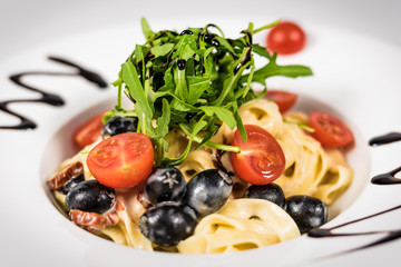 Pasta with vegetables on plate, traditional Italian food, pasta, tomatoes, rucola