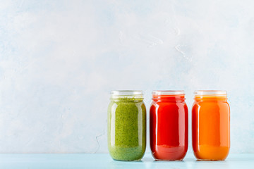 Orange/green/red colored smoothies / juice in a jar