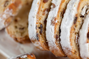 freshly baked cake with sweets, raisins and candied fruits, sprinkled with powdered sugar on a gray table