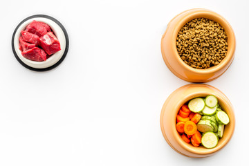 Ingredients for dry pet food. Meat and vegetables zucchini and carrot on white backgroud top view copy space