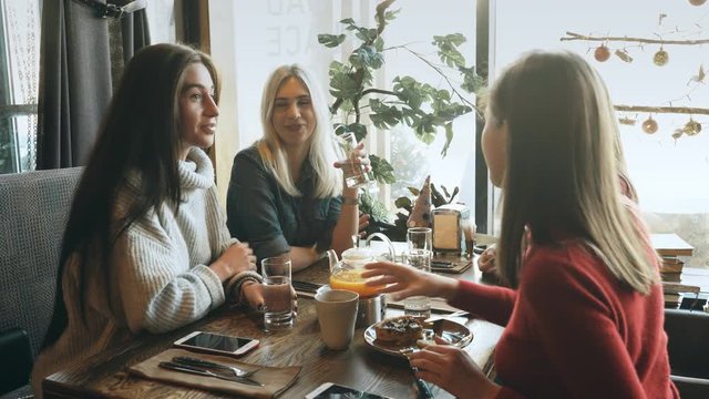 Four female friends enjoying in talking at cafe