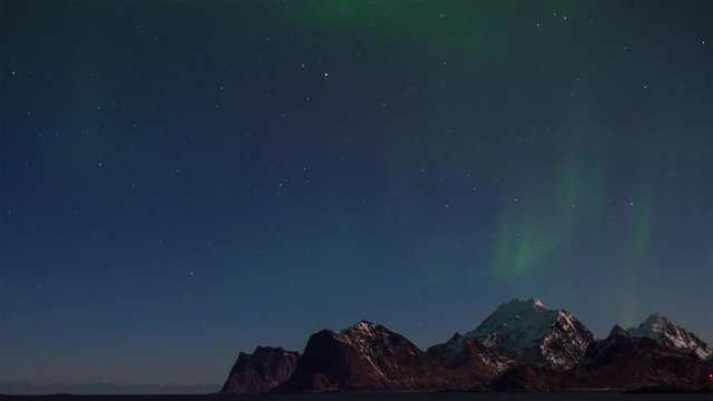 Northern lights (aurora borealis) over the mountains in Lofoten islands, Norway. Night winter landscape with polar lights and beautiful starry sky. Time-lapse video