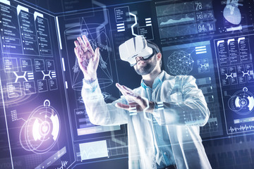 Careful touch. Smart experienced progressive doctor carefully touching the transparent screen while using virtual reality glasses in his scientific research