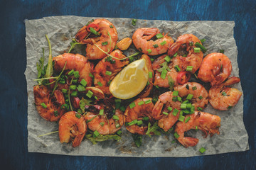 Large grilled BBQ shrimp with sweet chili sauce, green onion and lemon. Vintage toned image