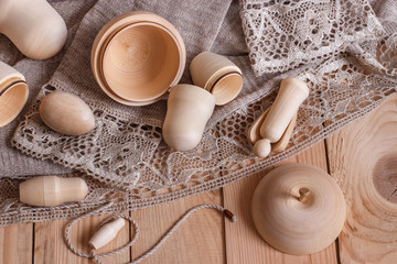 light wooden background with linen lace and wooden blanks for creativity