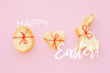 Homemade Easter cookies with red bow on pink background