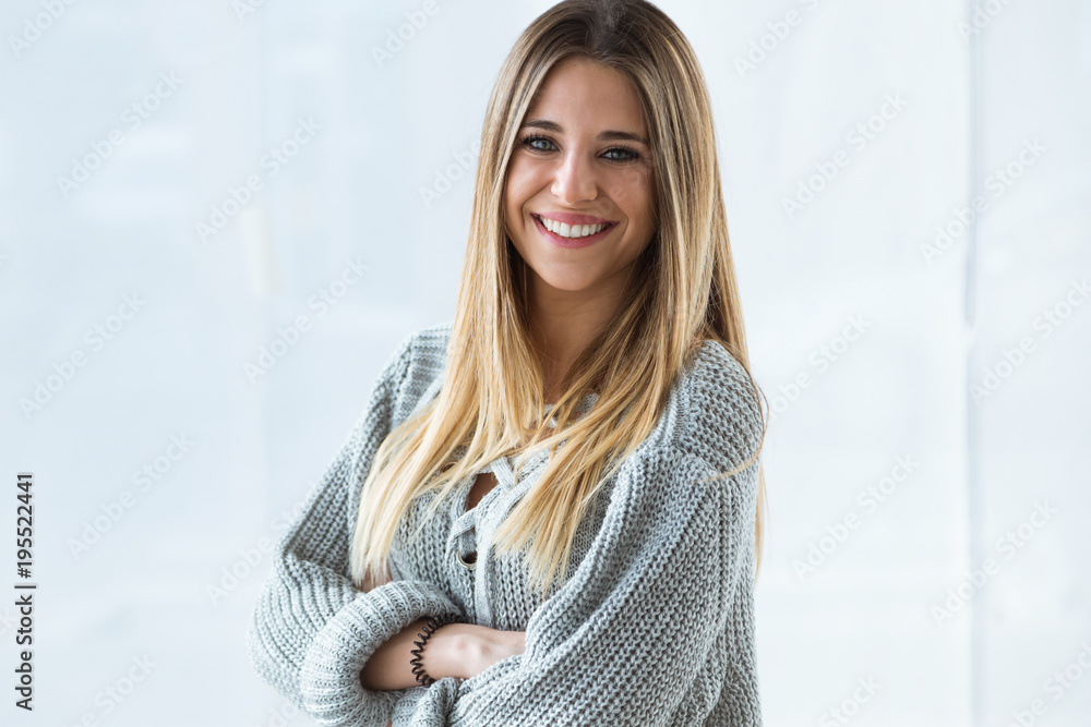 Wall mural beautiful young woman looking at camera at home.