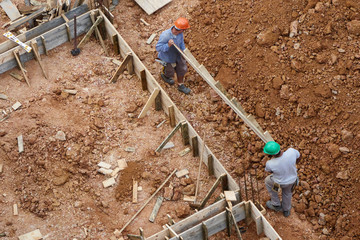 Bauarbeiter erstellen die Schalung f&uuml;r Streifenfundamente