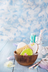 Easter cookies as egg in the wooden bowl with milk in glass on wood background