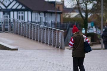 man in with red and white stripe sleaves walking in park looking like wheres wally