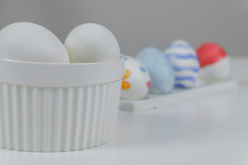 A table with white and colored eggs, prepared for decoration for Easter.