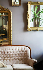 Vintage mirrors in frames and a sofa in the interior