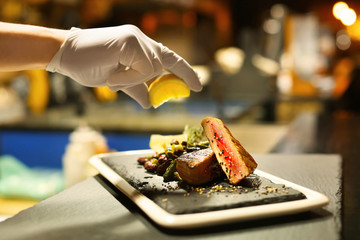 Chef preparing grilled tuna for serving in restaurant