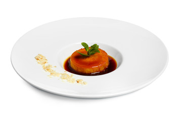 Plate with delicious flan on white background