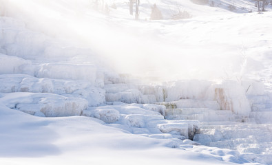 Fototapeta na wymiar Misty obscuring frost covered casade of Mammoth Hot Springs