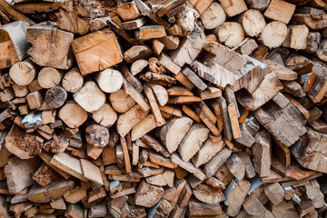 Background of dry chopped firewood logs in a pile