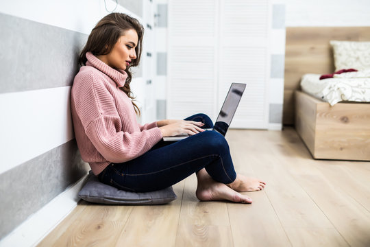 Young young woman sitting in the floor with laptop.