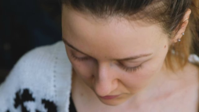 The beautiful girl covers the bruises under the eyes with a mineral corrector close-up, 4k