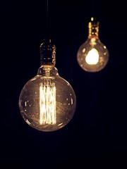 Low Key Image of Illuminating Vintage Incandescent Light Bulbs, Isolated on Dark Background.