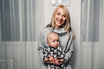 mother and little baby show different emotions in the camera