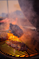 Delicious grilled beef steak with fire on background